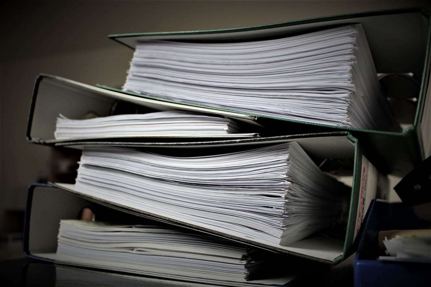 Stacked binders filled with paper documents